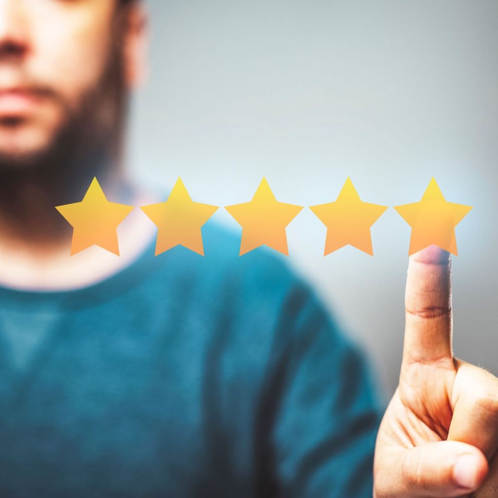 A close-up of a person pointing at five golden stars, representing a rating system.